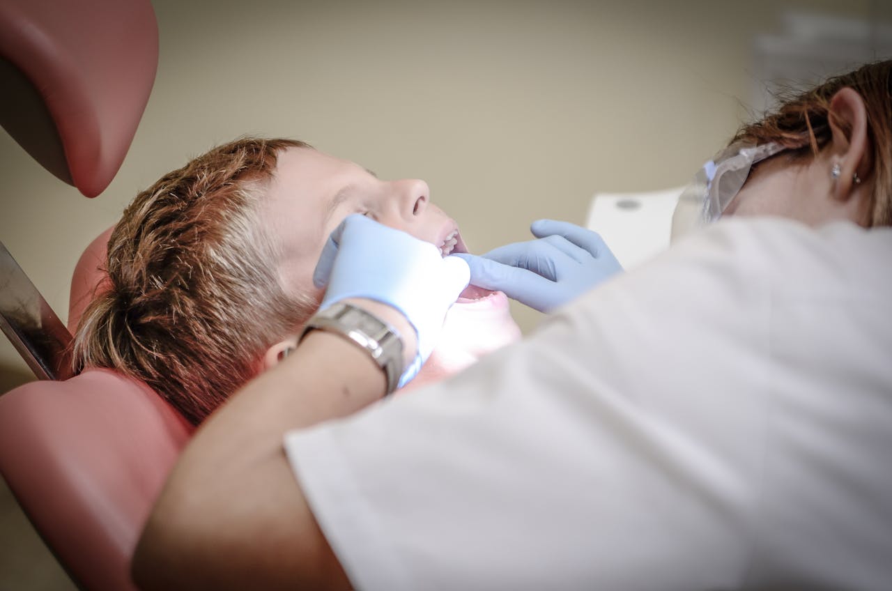 The Art of Drawing Readers In: Your attractive post title goes here A young boy receiving a dental examination by a professional dentist in a clinic setting.