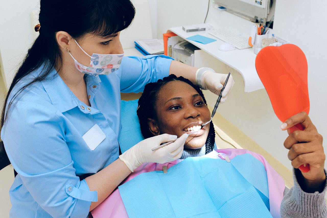 services-02 A female dentist checks a patient's teeth during a dental appointment.